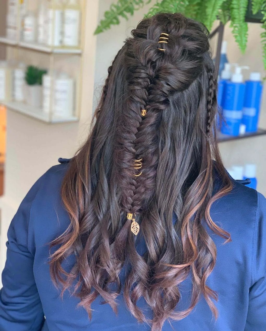 Luxurious brunette half-up style with a central Viking braid and golden charms.