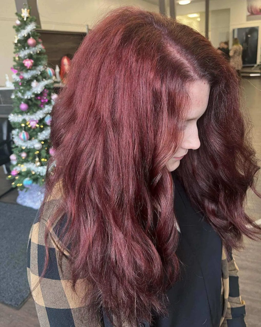 Brunette to crimson balayage with playful, bouncy waves.
