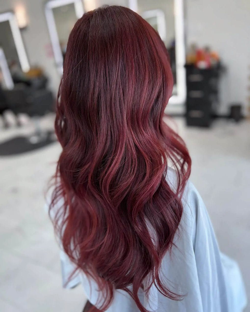 Burgundy to dark brunette roots in seamless red balayage.