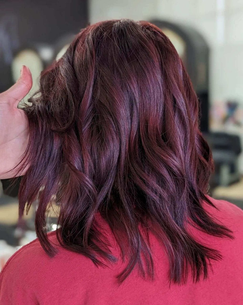 Shoulder-length brunette and vivid red balayage in tousled waves.