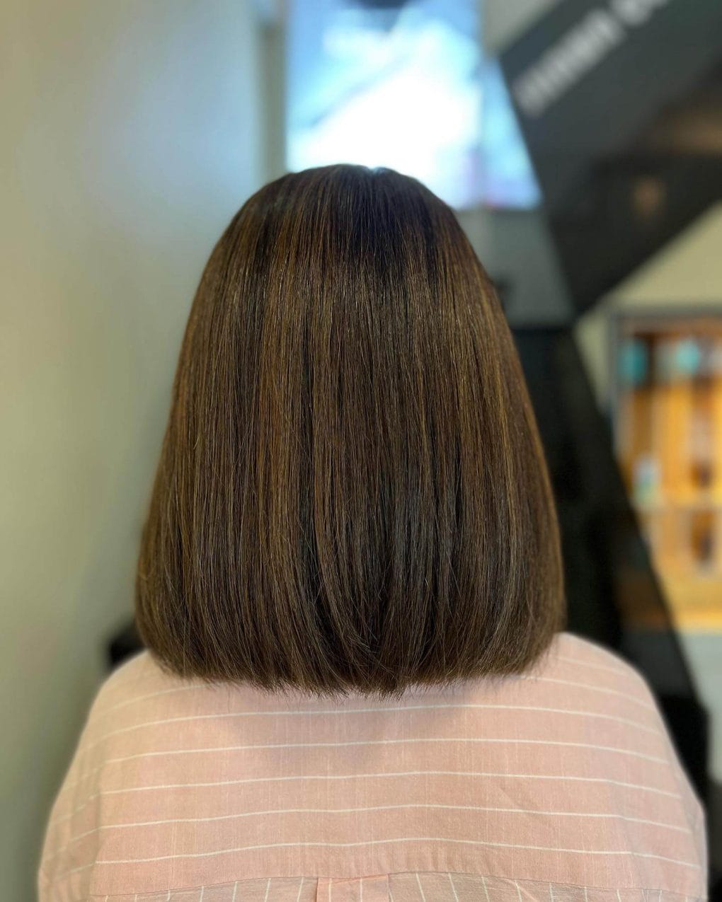 Straight bob with chocolate brown base and subtle balayage highlights, cut to shoulder length