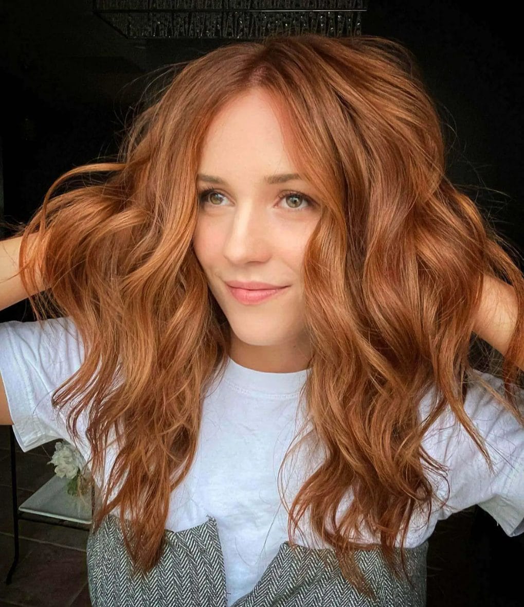 Tousled, beachy cinnamon red waves with soft layers.