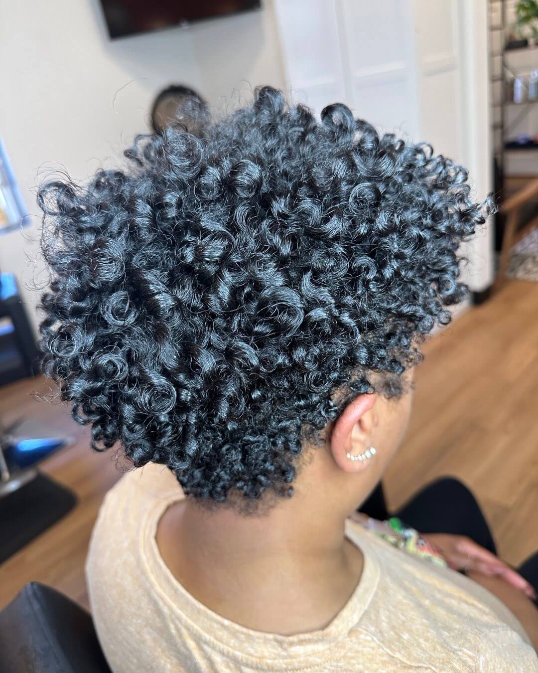 Natural curly crop with tapered precision.