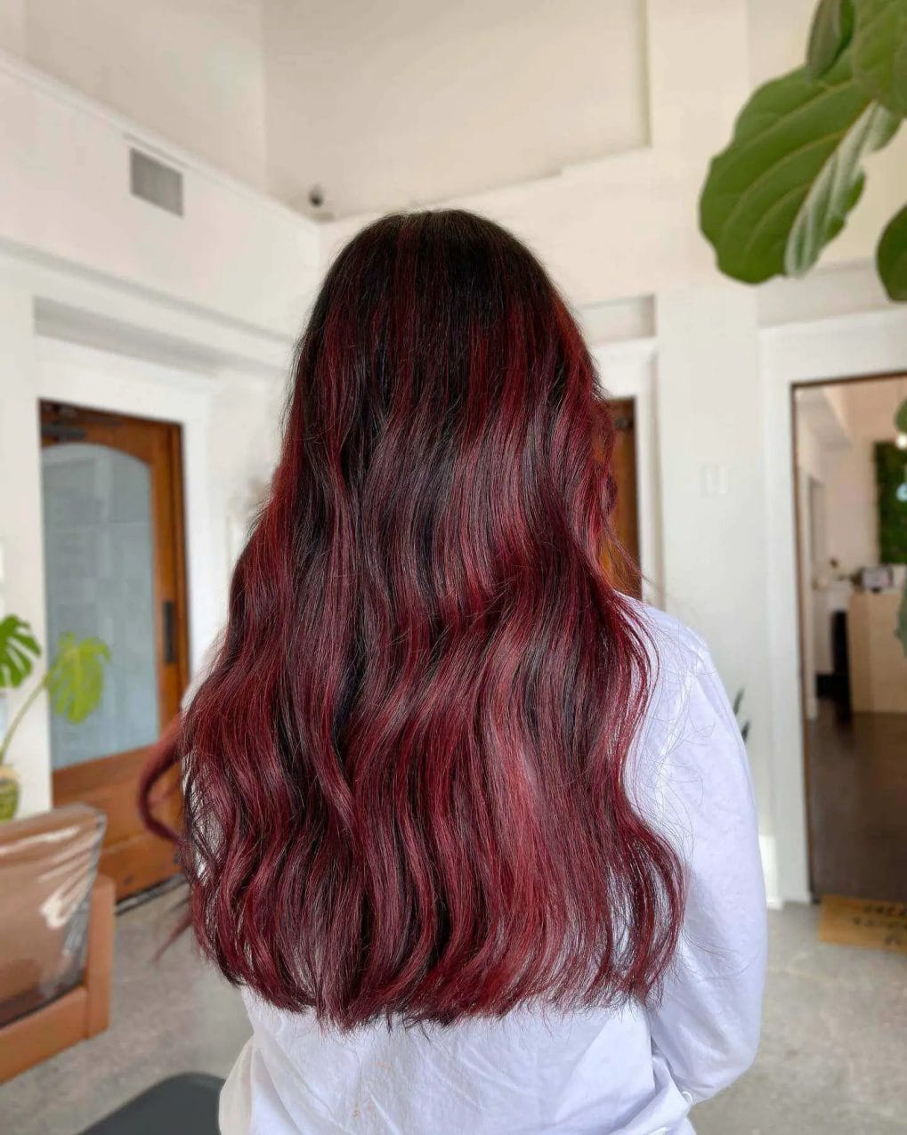 Deep brunette to burgundy red balayage, long flowing layers.