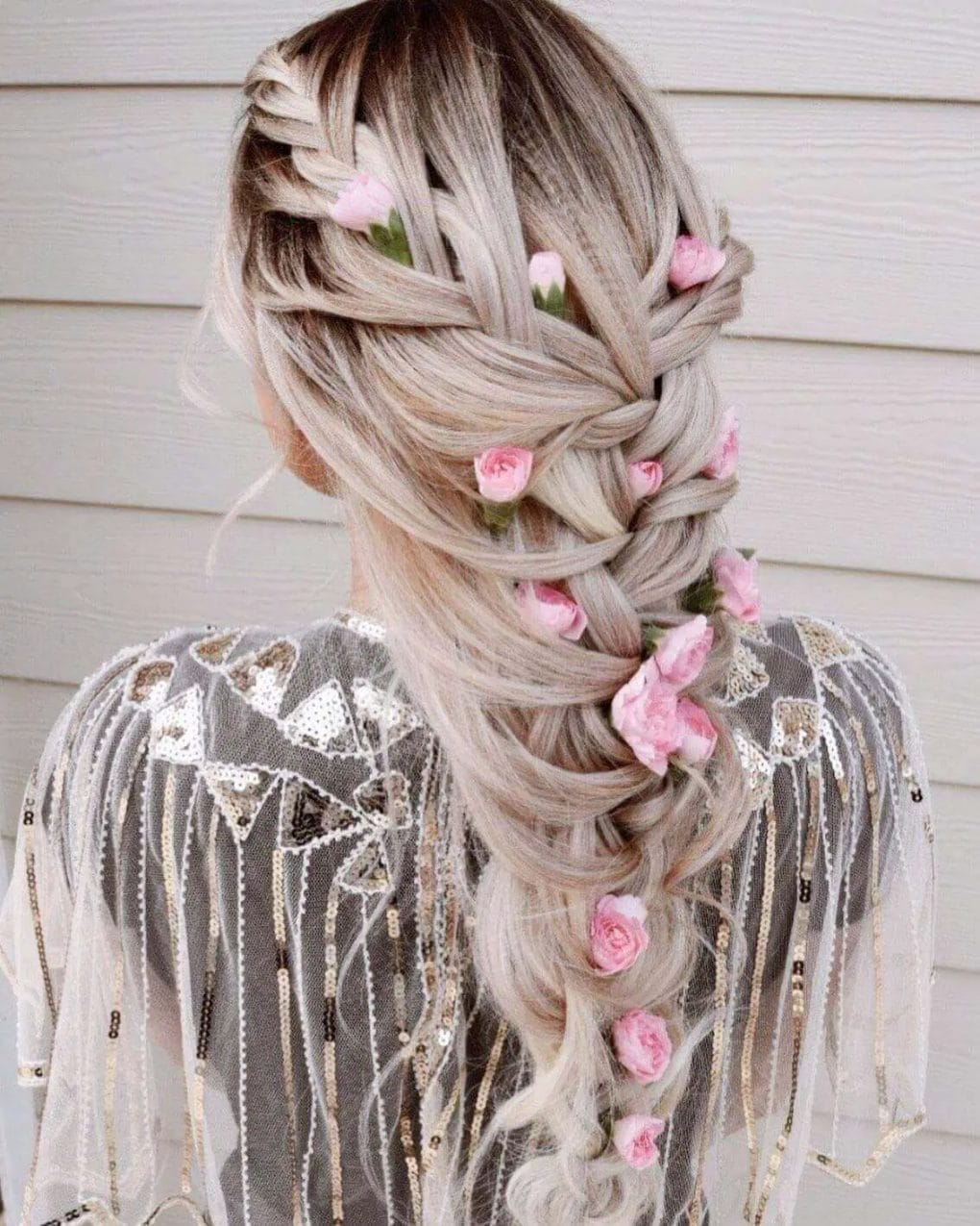 Whimsical dual French braids with pink blossoms in ash and platinum blonde.