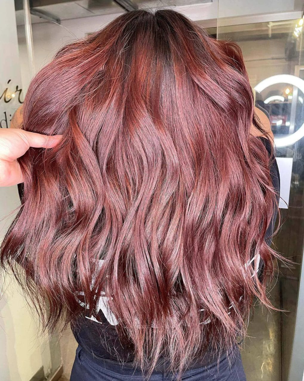 Dynamic red balayage on mid-length brunette, tousled layers.