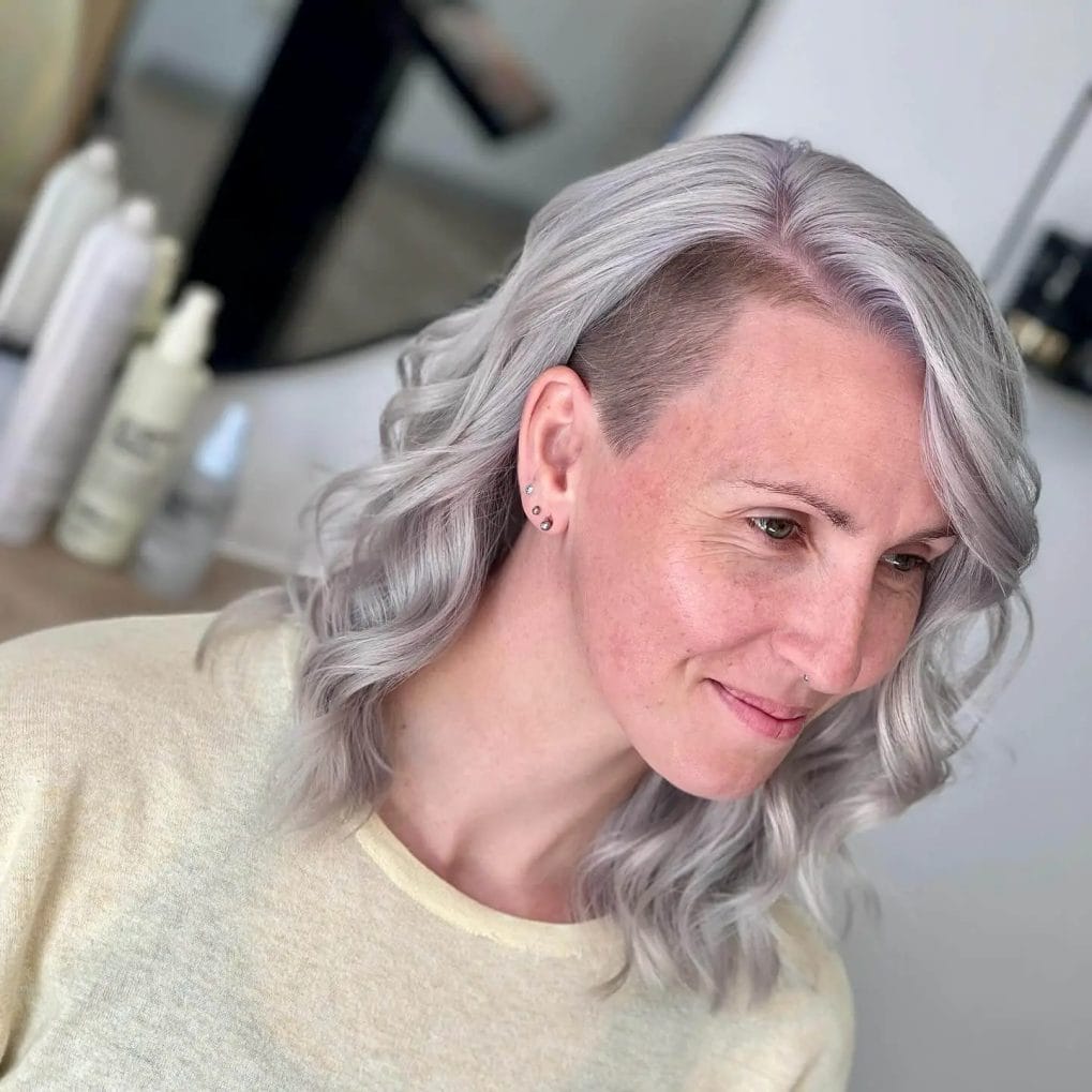 Icy blonde waves with a modern undercut along the sides.
