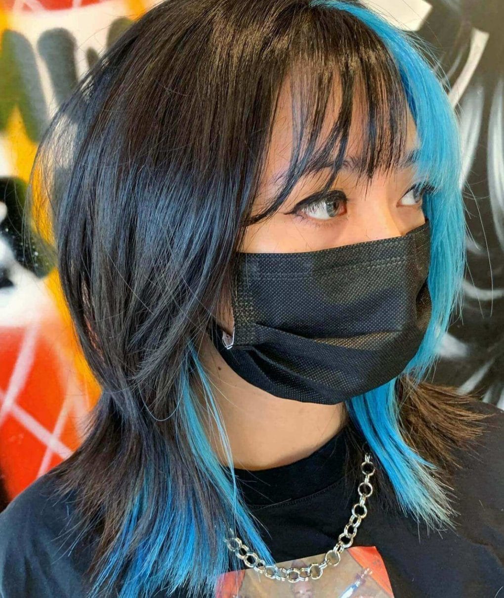 Wolf cut with electrifying baby blue highlights and choppy fringe.