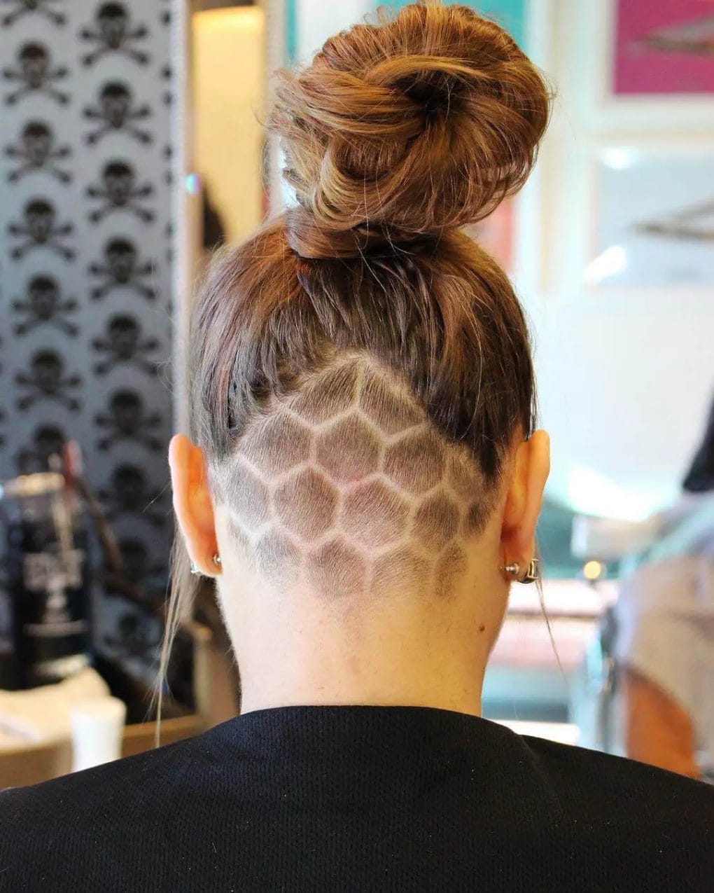 A high bun over a detailed undercut with a honeycomb pattern.