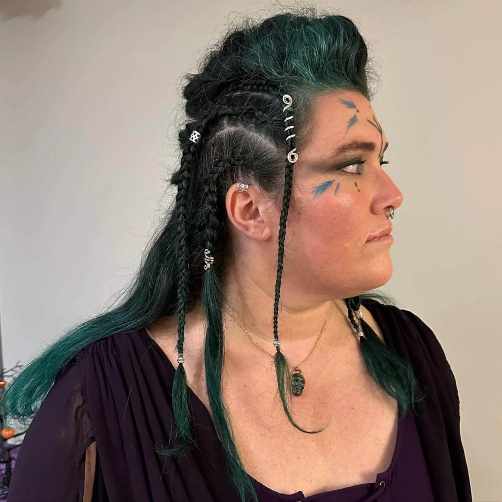 Emerald green, layered hair with tight Viking braids adorned with beads.