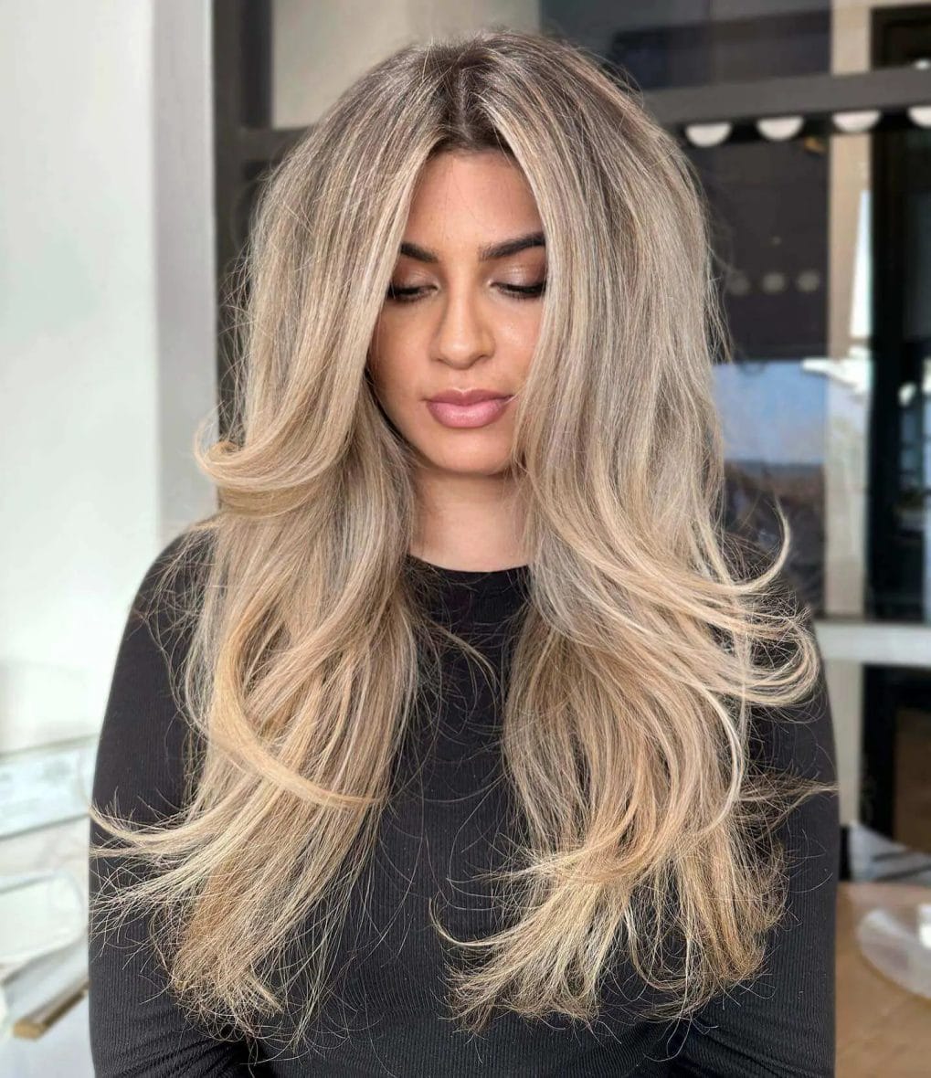 Blonde balayage blending cool ash and warm honey tones in flowing blowout layers.
