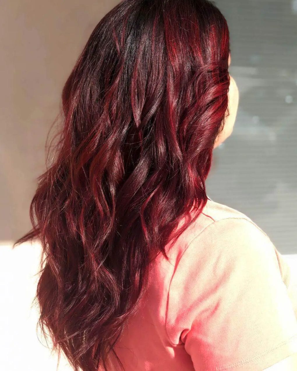 Fiery red balayage on long brunette, ember-like effect.