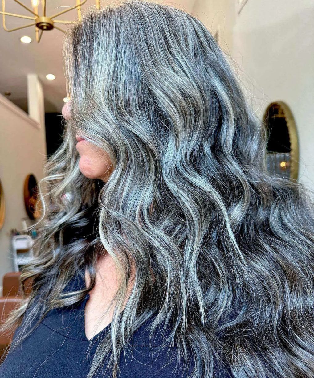 Full-bodied mane with textured waves in silver and ash balayage.