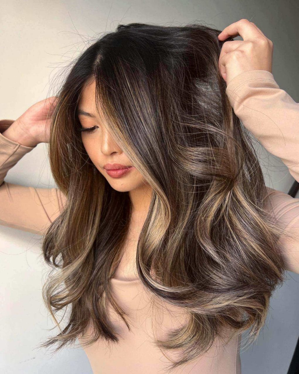'Bronde' balayage blending brunette roots with lighter ends, styled in layers with a blowout