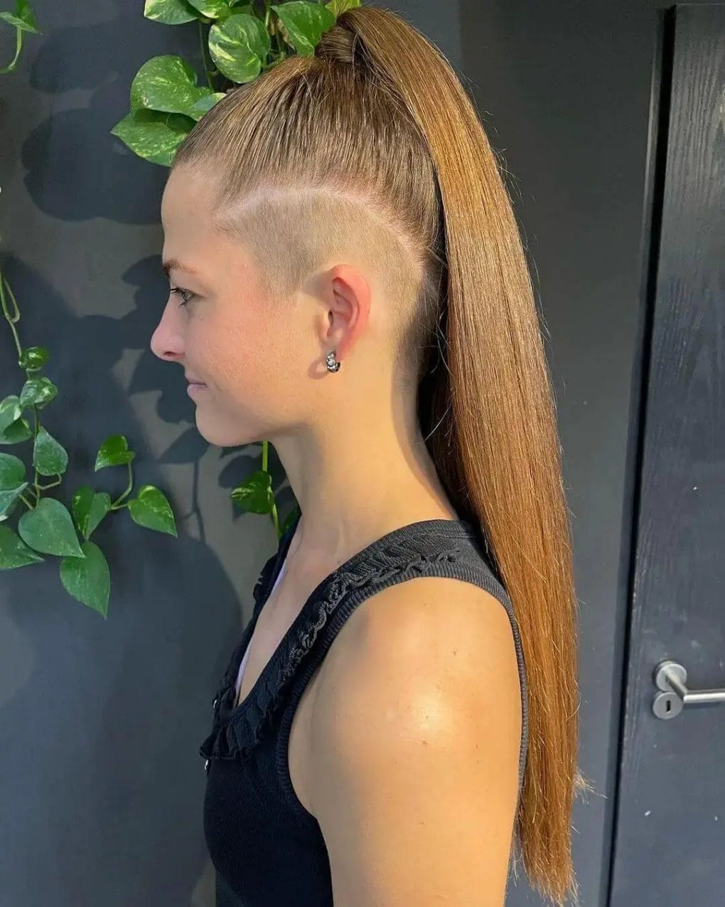 A polished, high ponytail in honey blonde with a neat, subtle undercut at the nape.