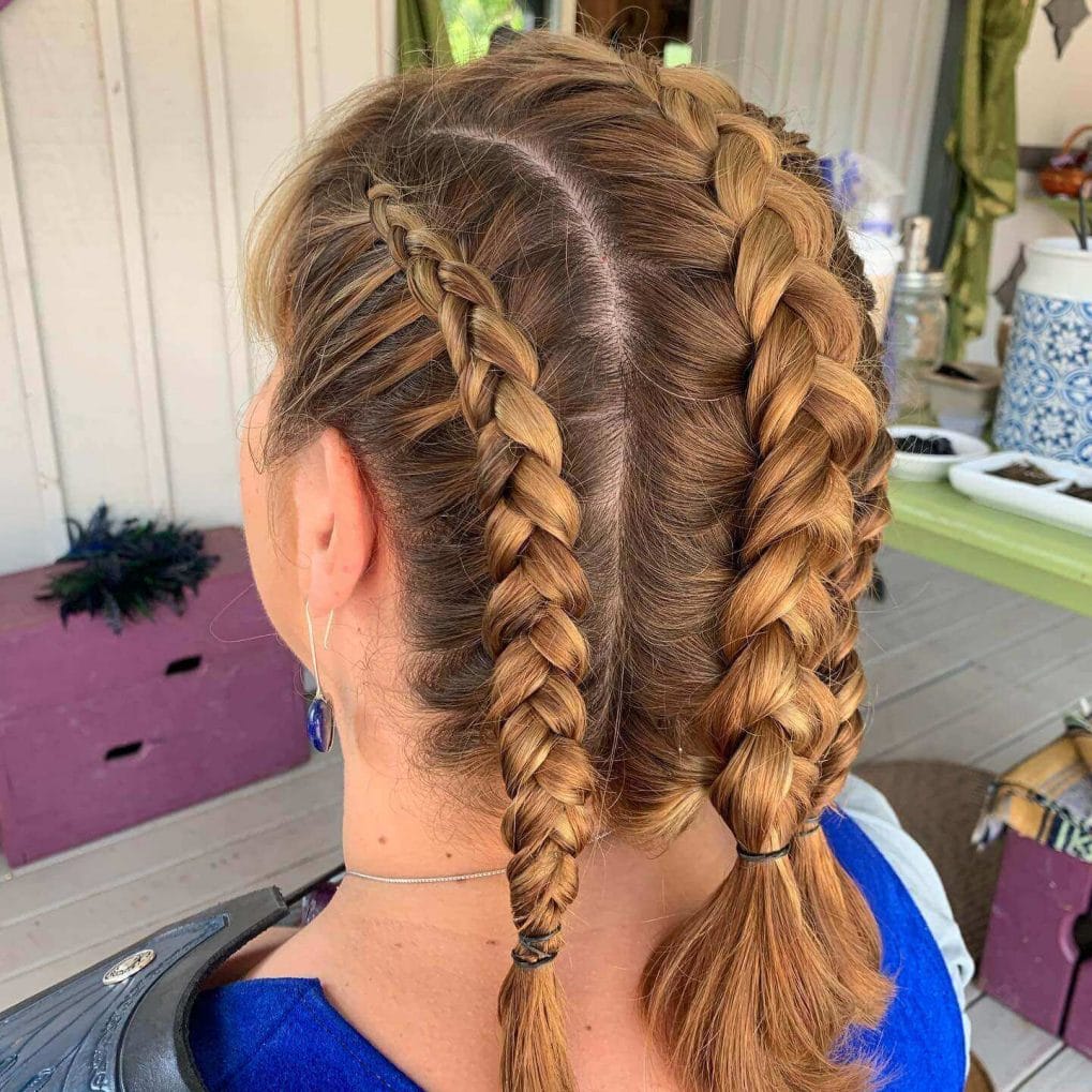 Honey-blonde hair with dual Viking braids mimicking a mohawk and showcasing natural texture.