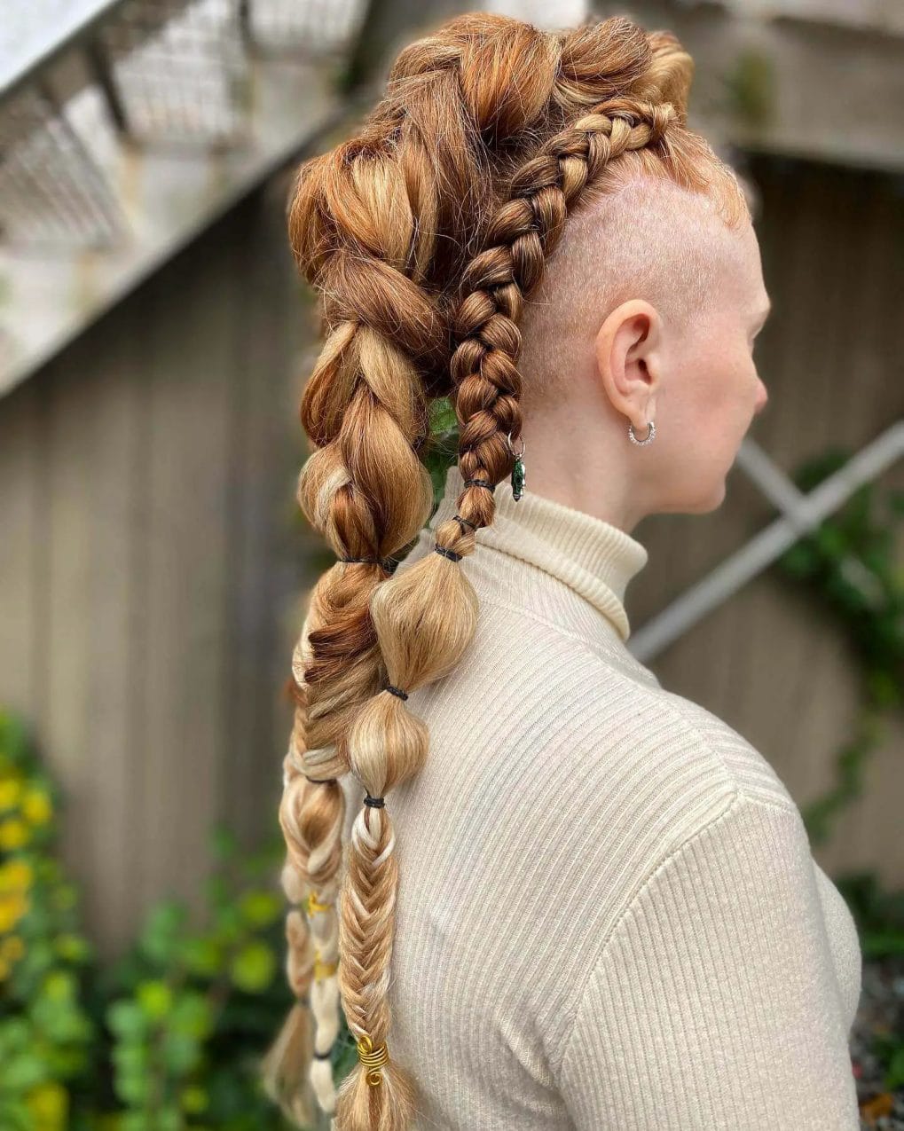 Honey-blonde Viking braids with a shaved side and bubbled sections.