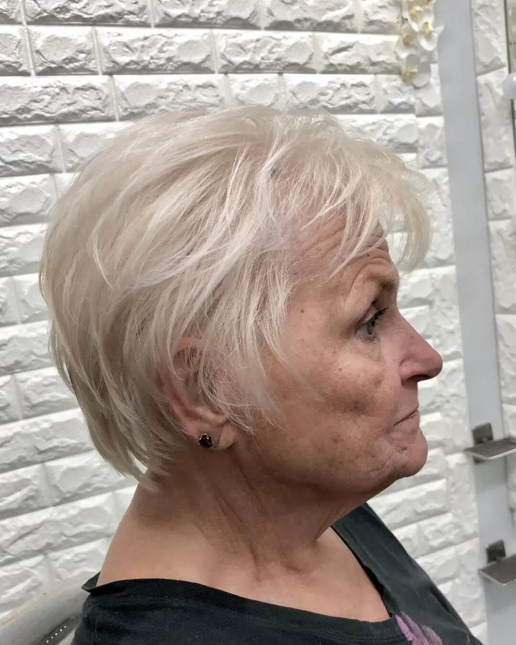 Chic icy blonde textured pixie cut with voluminous layers.