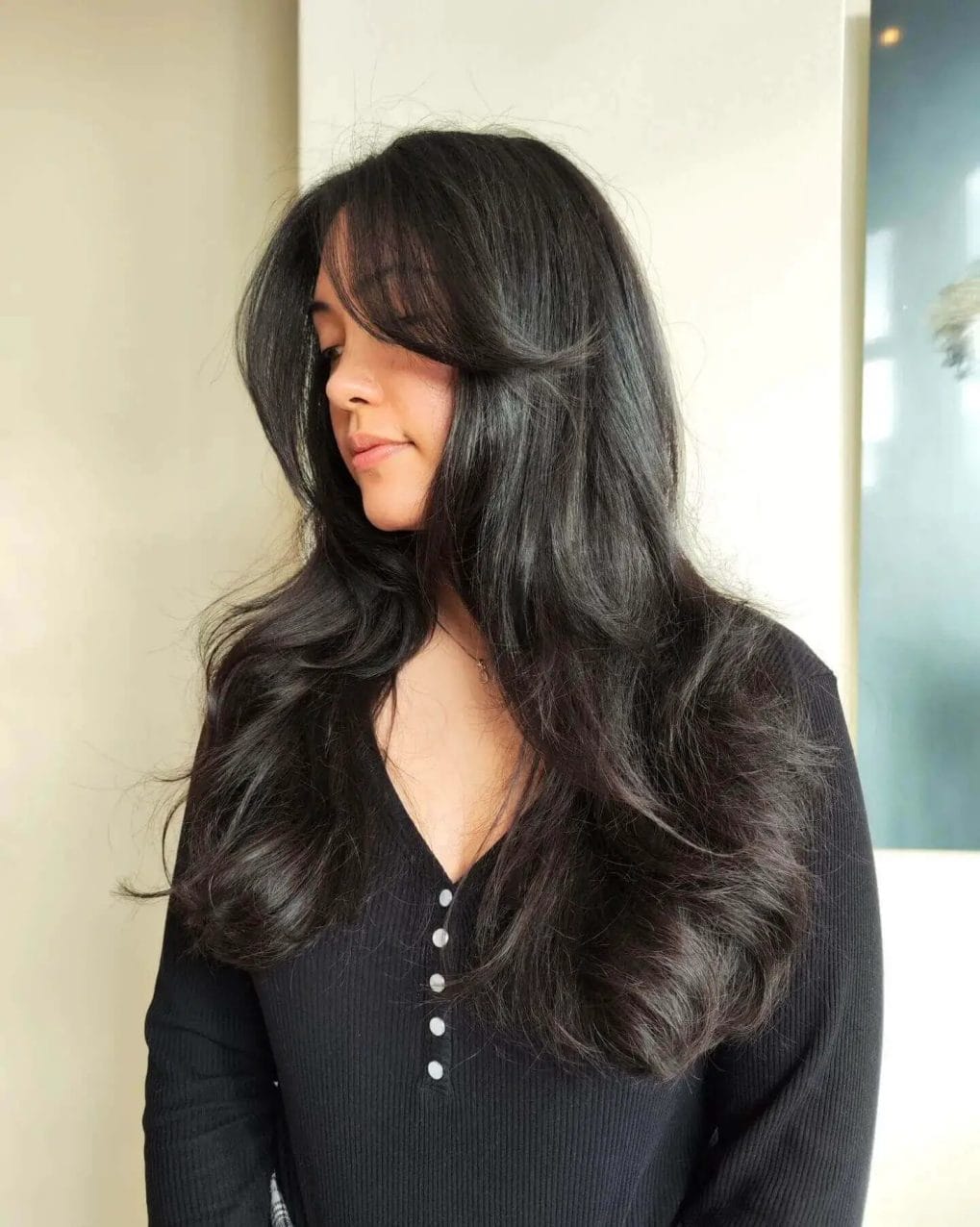 Timeless jet-black hair with lustrous shine, soft wavy blowout layers.