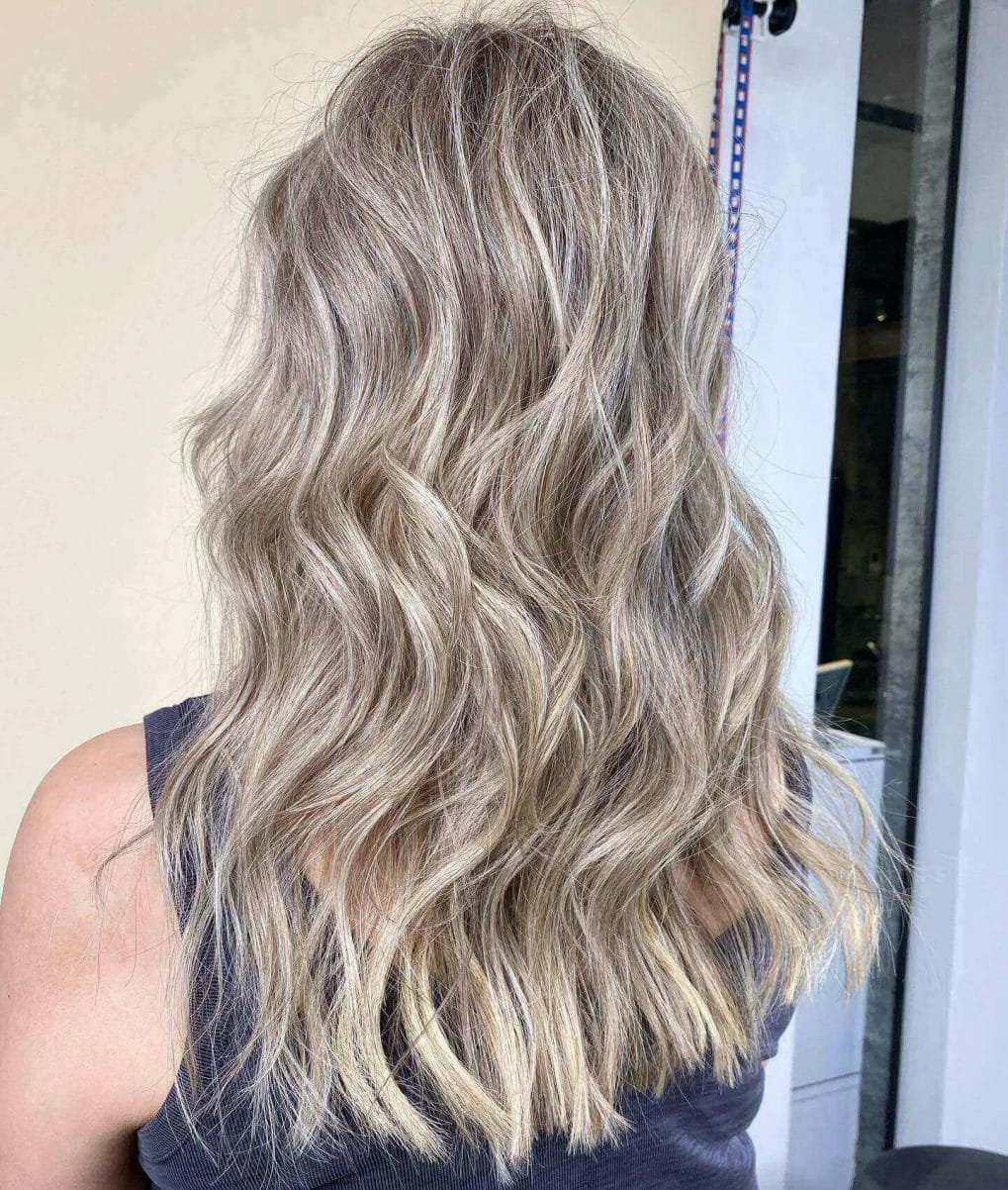 Layered waves mixing cool ash and warm blonde for a dynamic look.