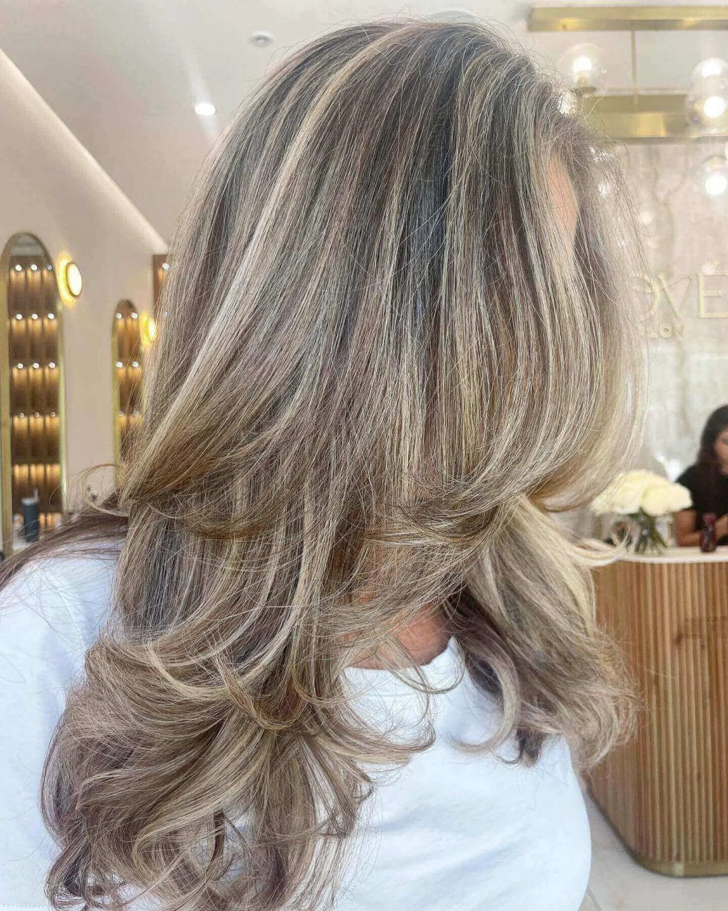Long, layered blend of dimensional blondes and natural gray.
