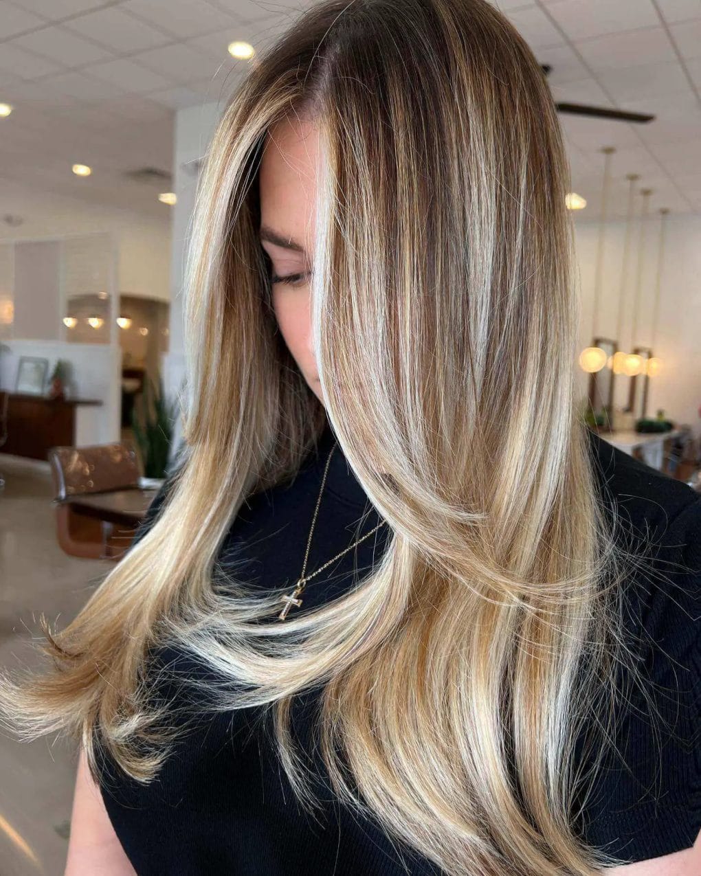 Long hair with layered blowout, voluminous waves, and blonde highlights.