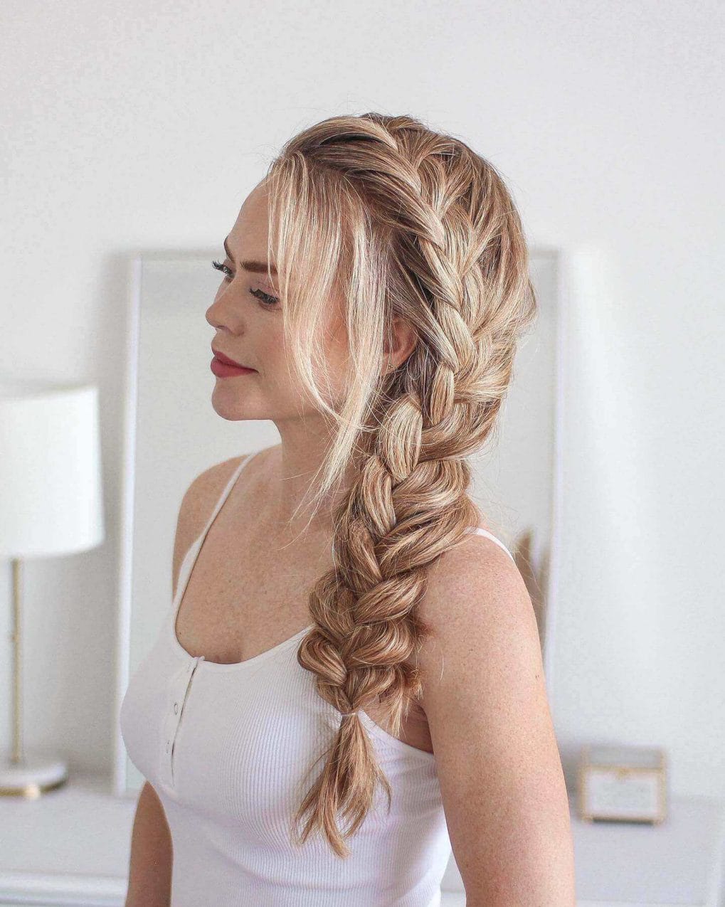 Effortlessly romantic, loose French braid with warm blonde layers.