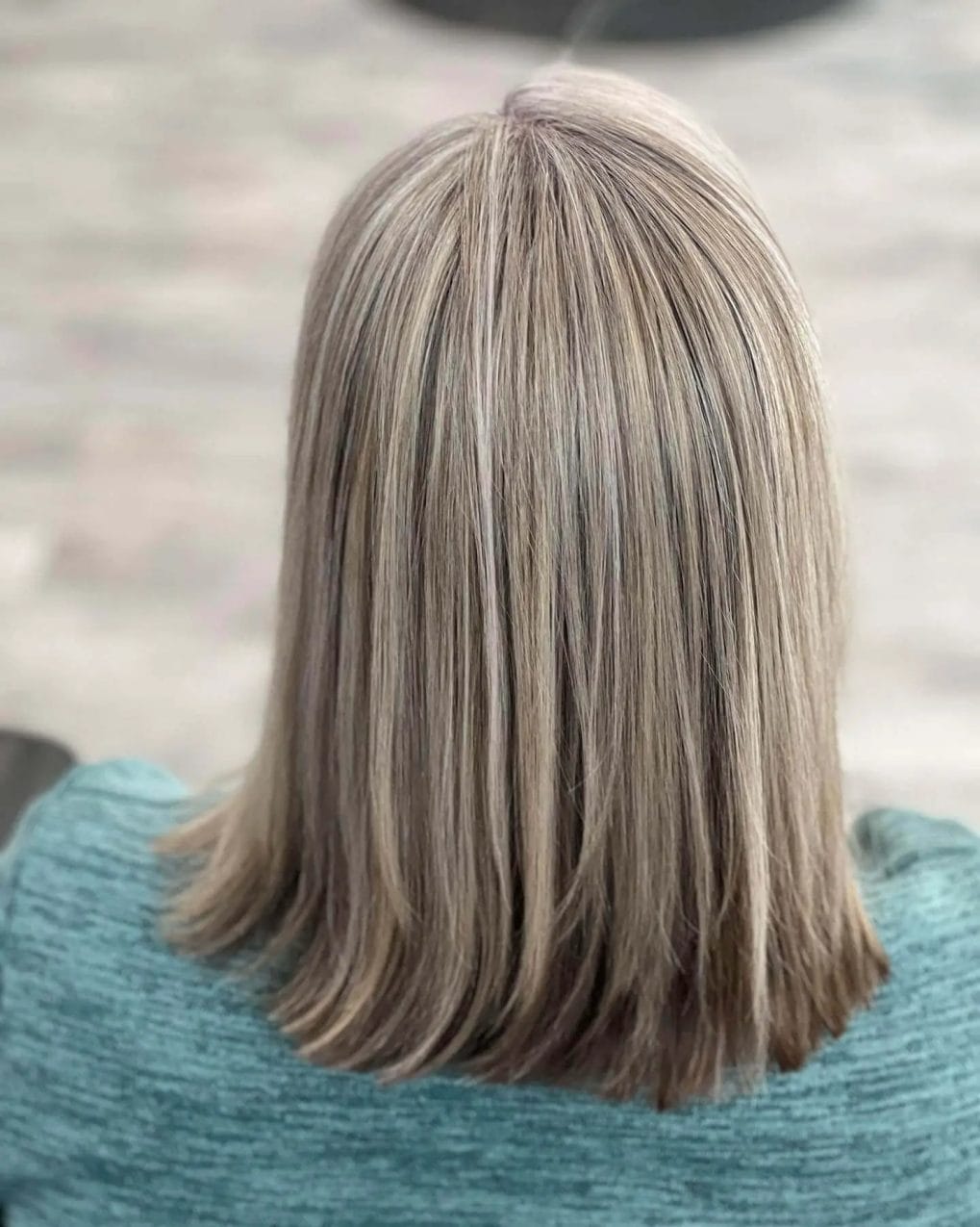 Chic mid-length ash blonde and gray blend in a sleek, straight style.