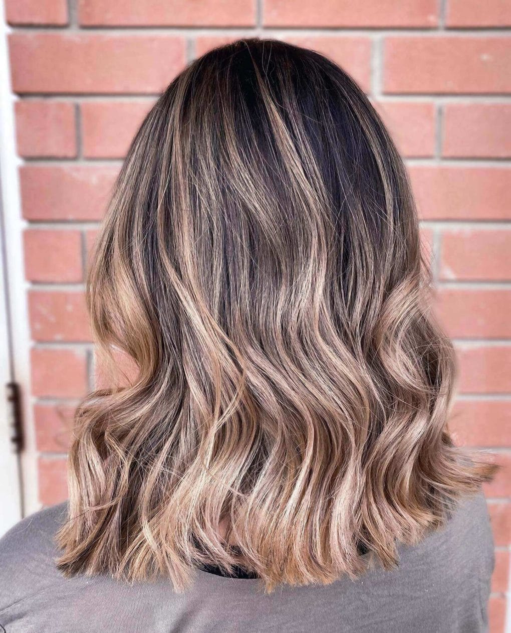 Mid-length lob, honey balayage with seamless layering.