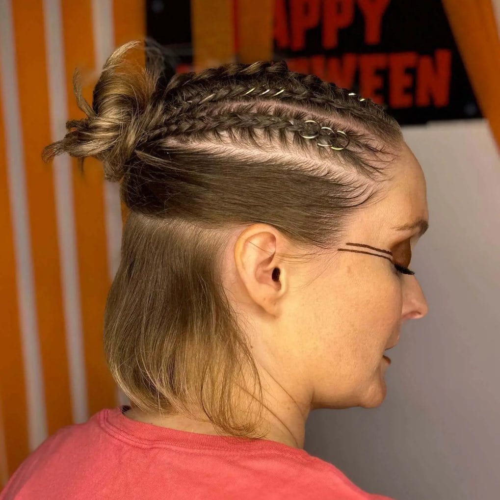 Light brown hair with tight Viking braids and a casual top knot.