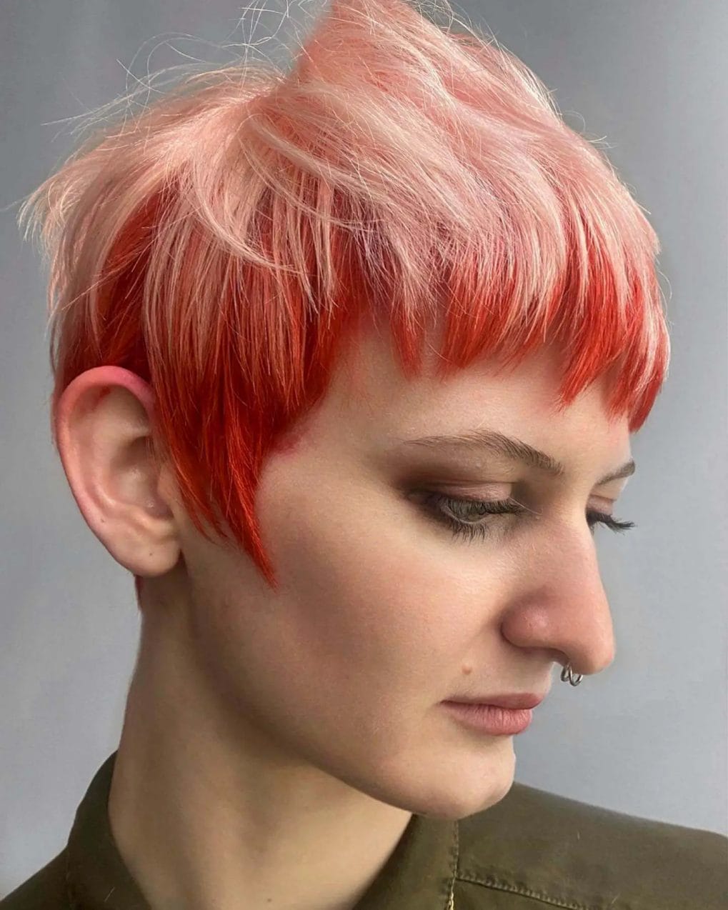 Playful peach to vibrant red ombre in edgy pixie cut.