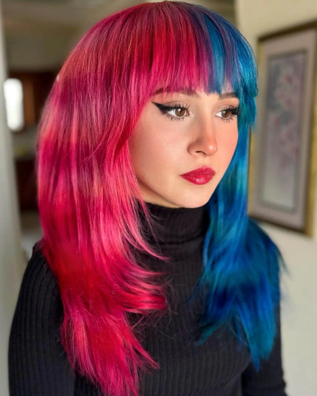 Vivacious pink and blue split dye with full bangs in long layers.