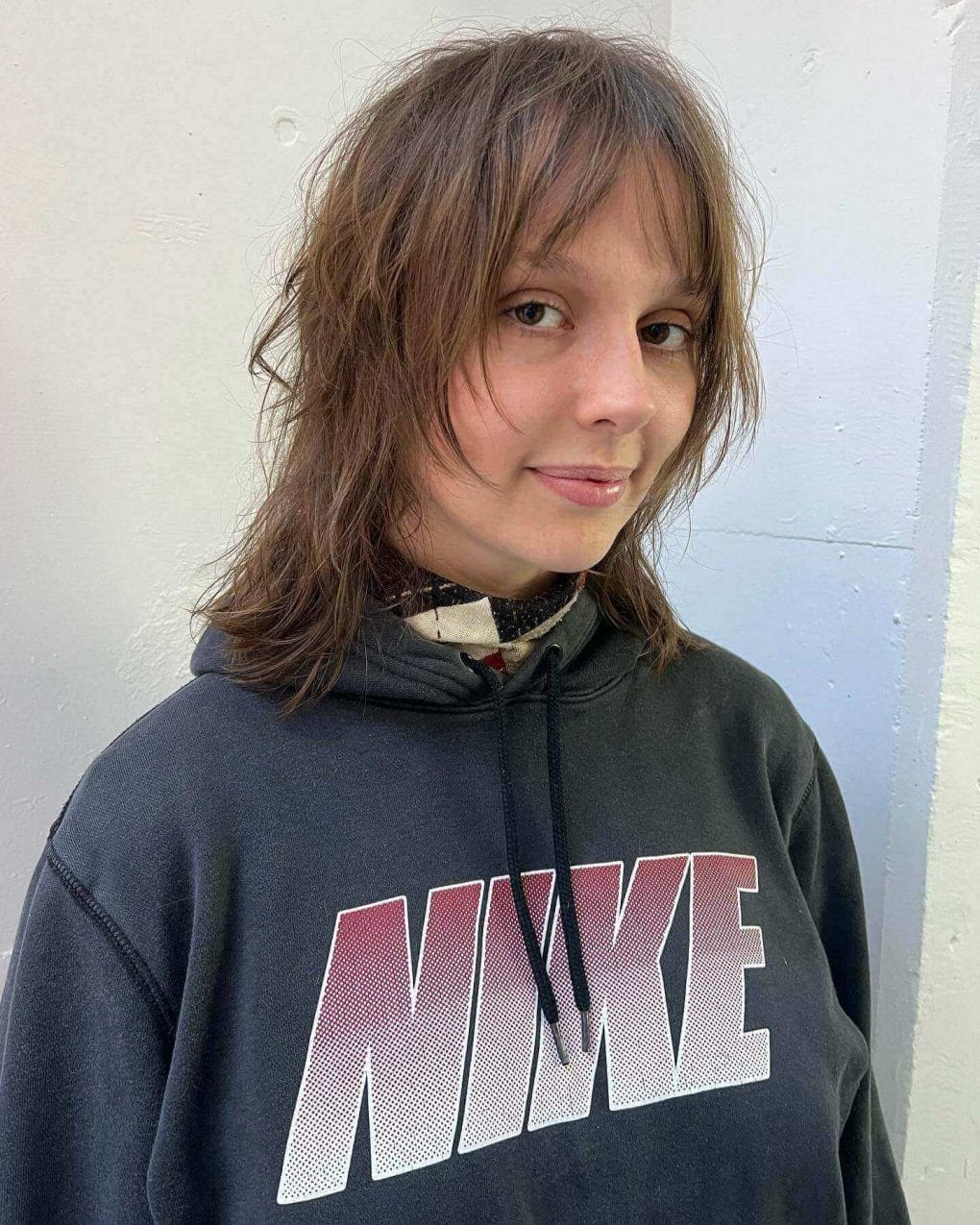 Relaxed chestnut brown wolf cut with feathered layers and piecey fringe.