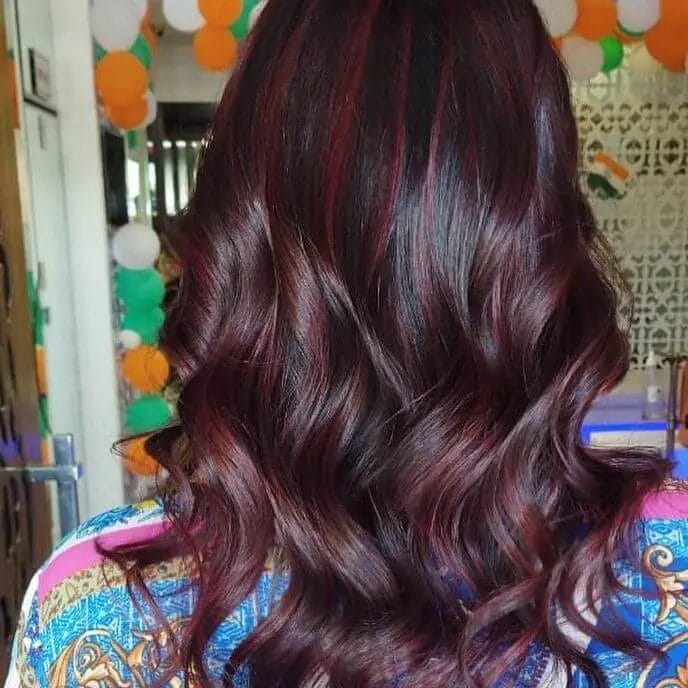 Ruby balayage blending into brunette, luxurious waves.