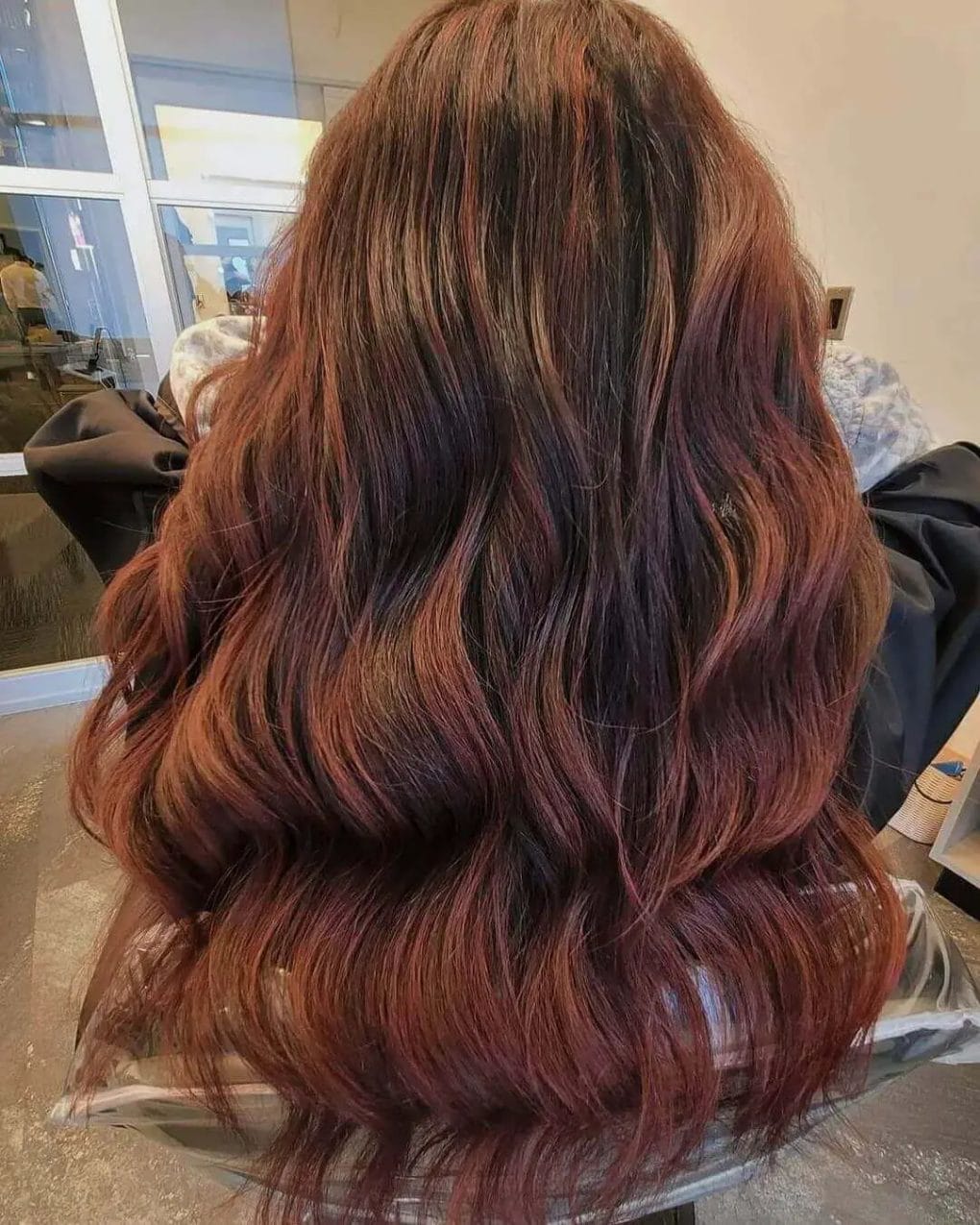 Seamless red to auburn balayage on brunette, full-bodied layers.