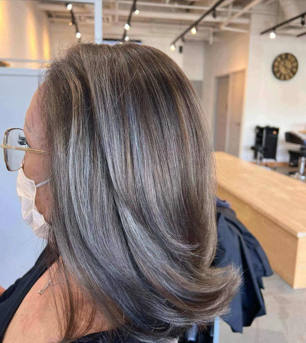 Shoulder-length hair blending natural gray and ash tones.