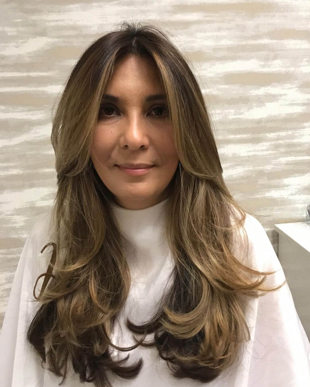 Graceful shoulder-length cut with warm balayage highlights and layers.