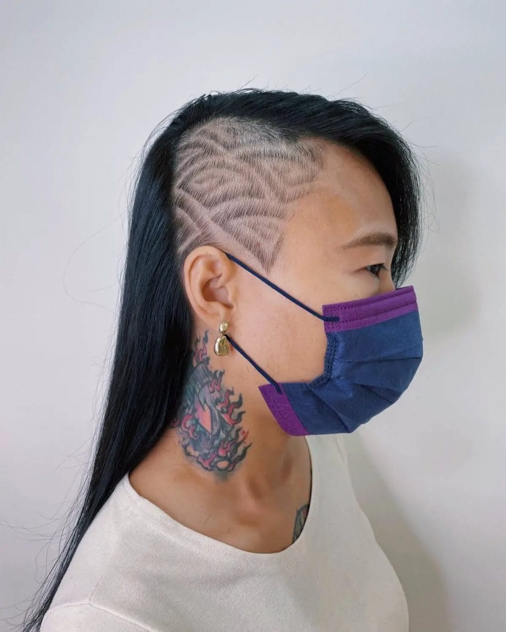 Long, sleek black hair with a detailed, leaf-patterned undercut on one side.