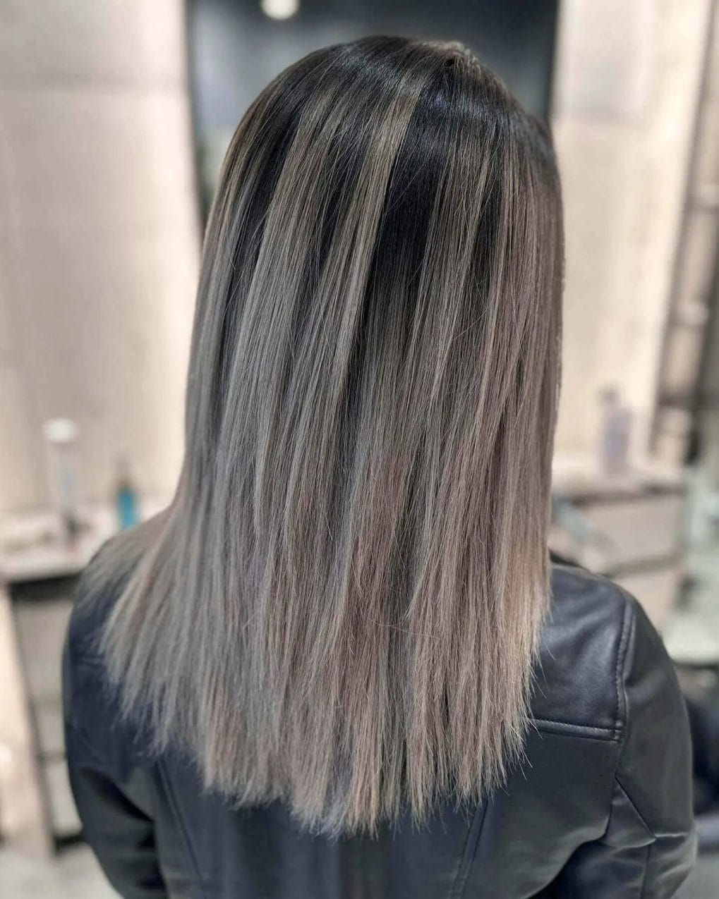 Sleek, shoulder-length hair with dark roots and silvery ash balayage.