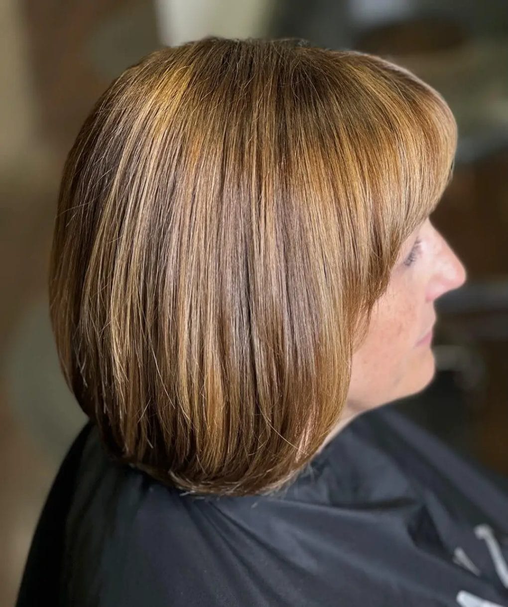 Soft layered bob with honey caramel highlights for a warm look.