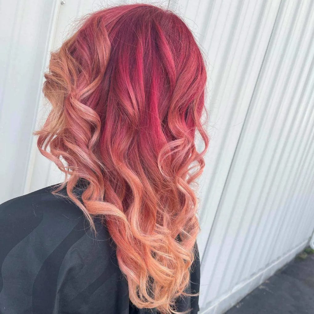 Strawberry blonde curls with a fiery red balayage.