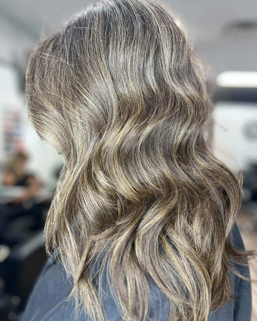 Natural sun-kissed balayage weaving cool grays and warm blondes in layers.