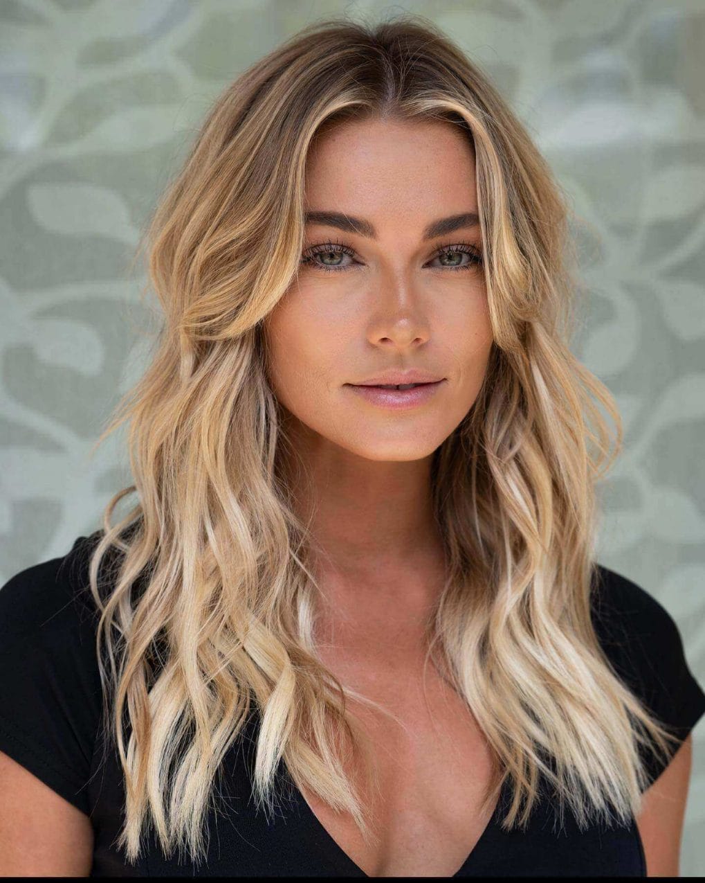 Beachy waves with gradient balayage from brunette roots to golden blonde ends, long layers framing the face