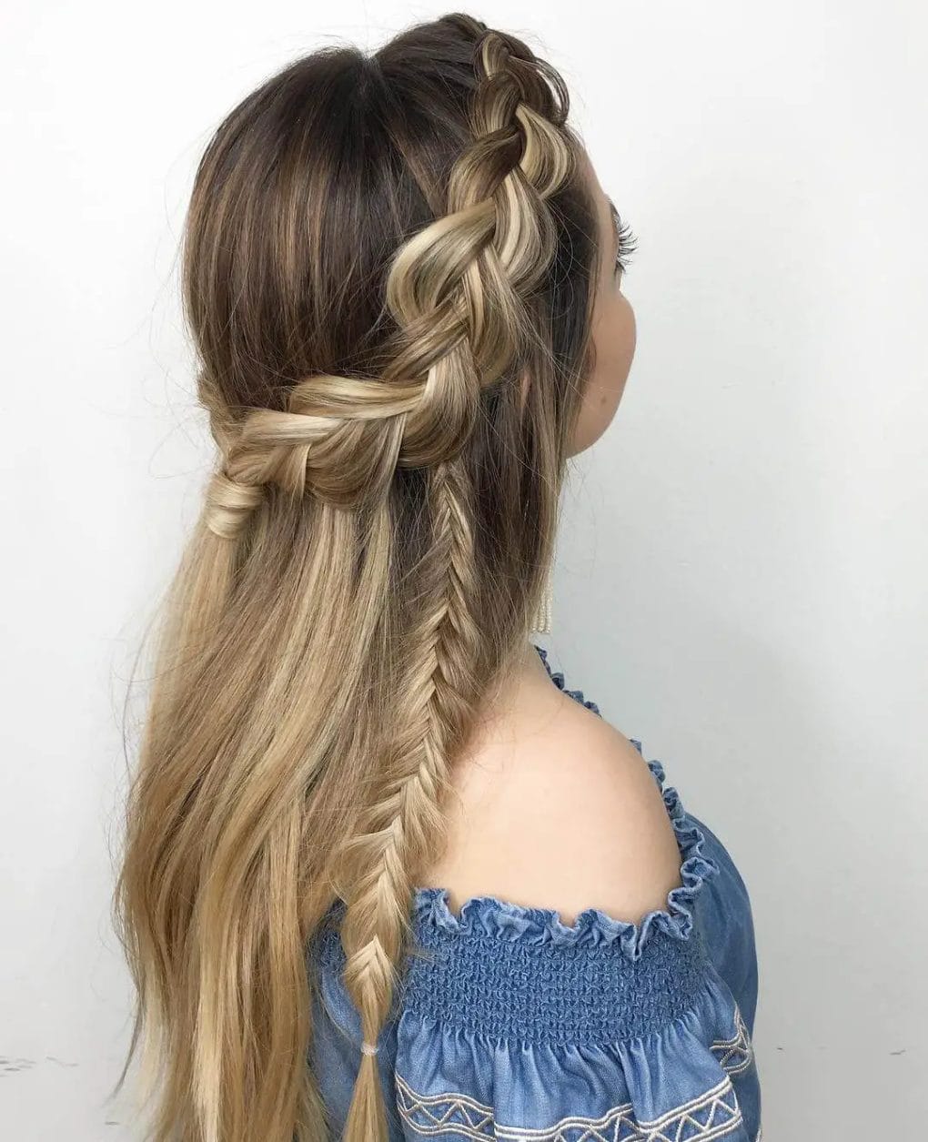 Multi-tonal blonde hair with a loose, side Viking braid and relaxed waves.
