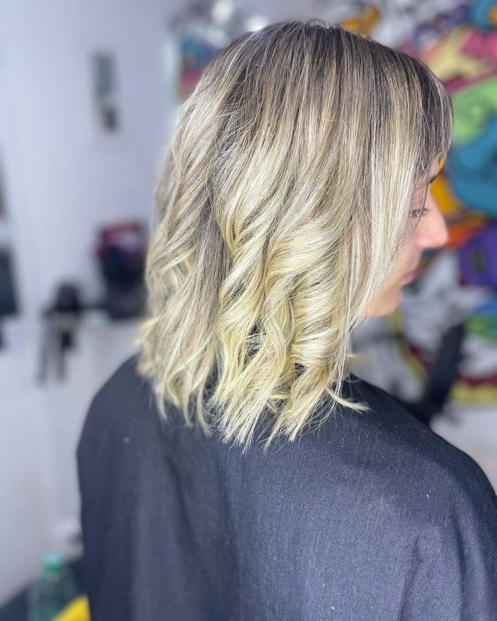 Textured bob with dark roots and blonde hues.