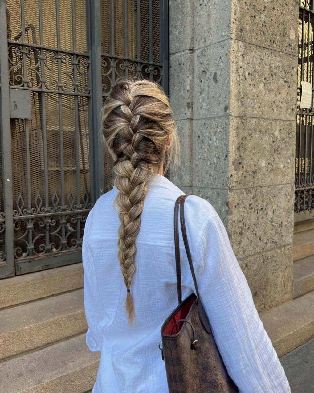 Voluminous crown French braid with honey blonde and light brown highlights.