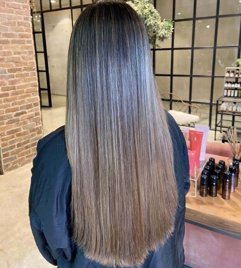 Long straight hair with balayage transition from dark ash to silvery blonde.