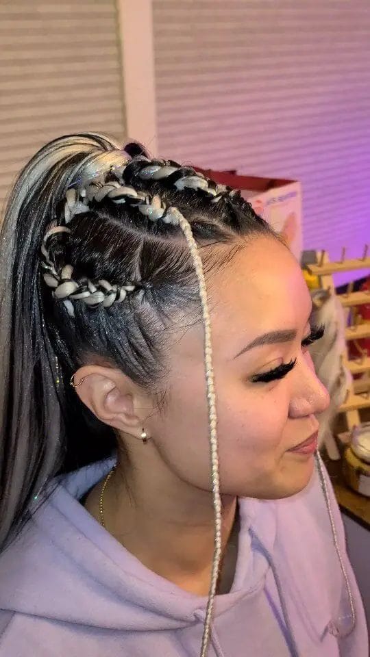 Cornrows with silver rings on one side transitioning to sleek straight hair