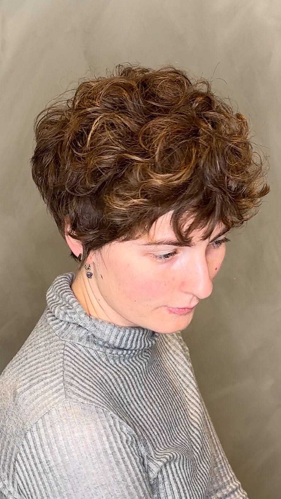 Textured auburn curls layered for voluminous crown pixie