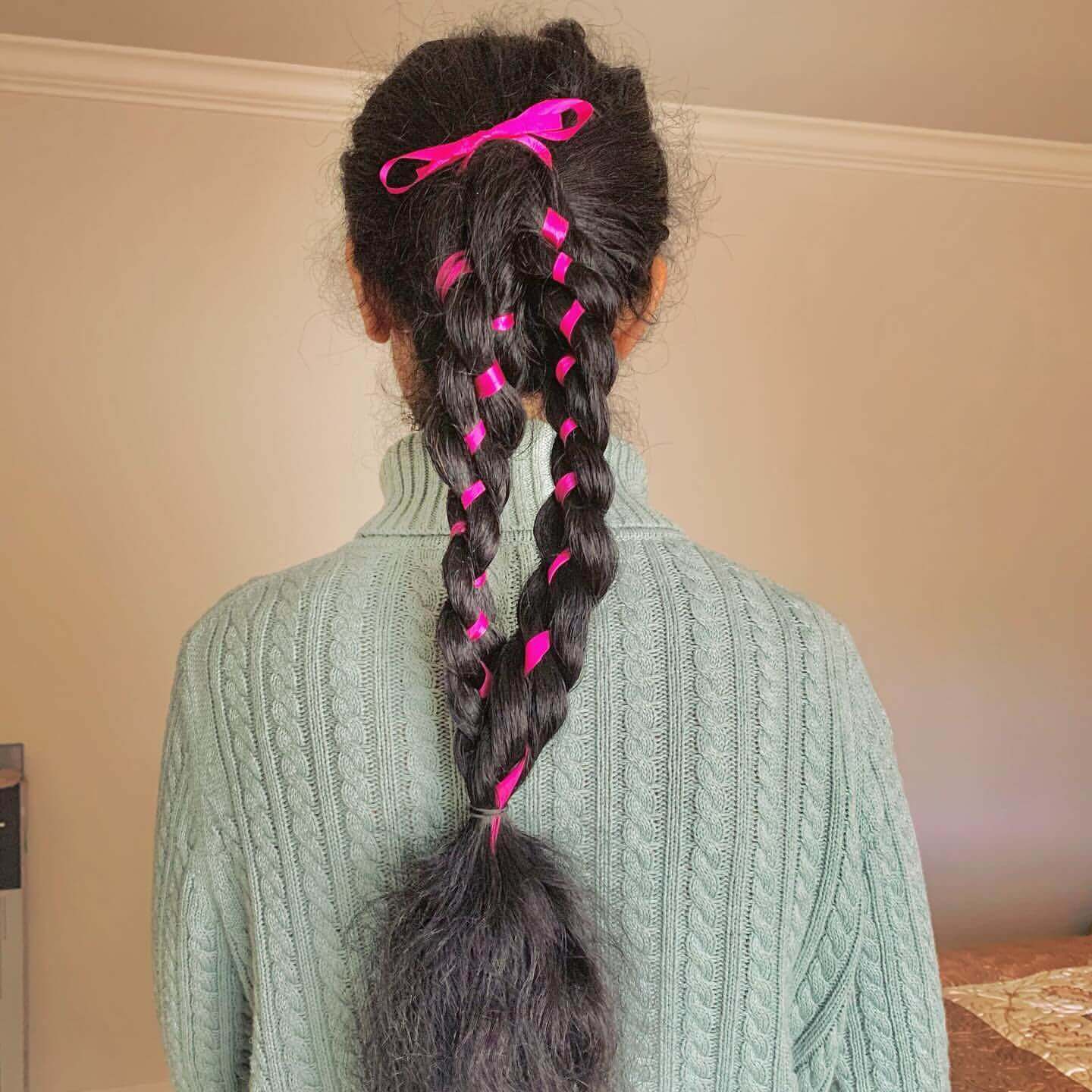 Playful ribbon braid with pink ribbons tied into a bow for school